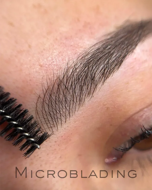 Microblading en primer plano: pelos trazados a mano junto al cepillo